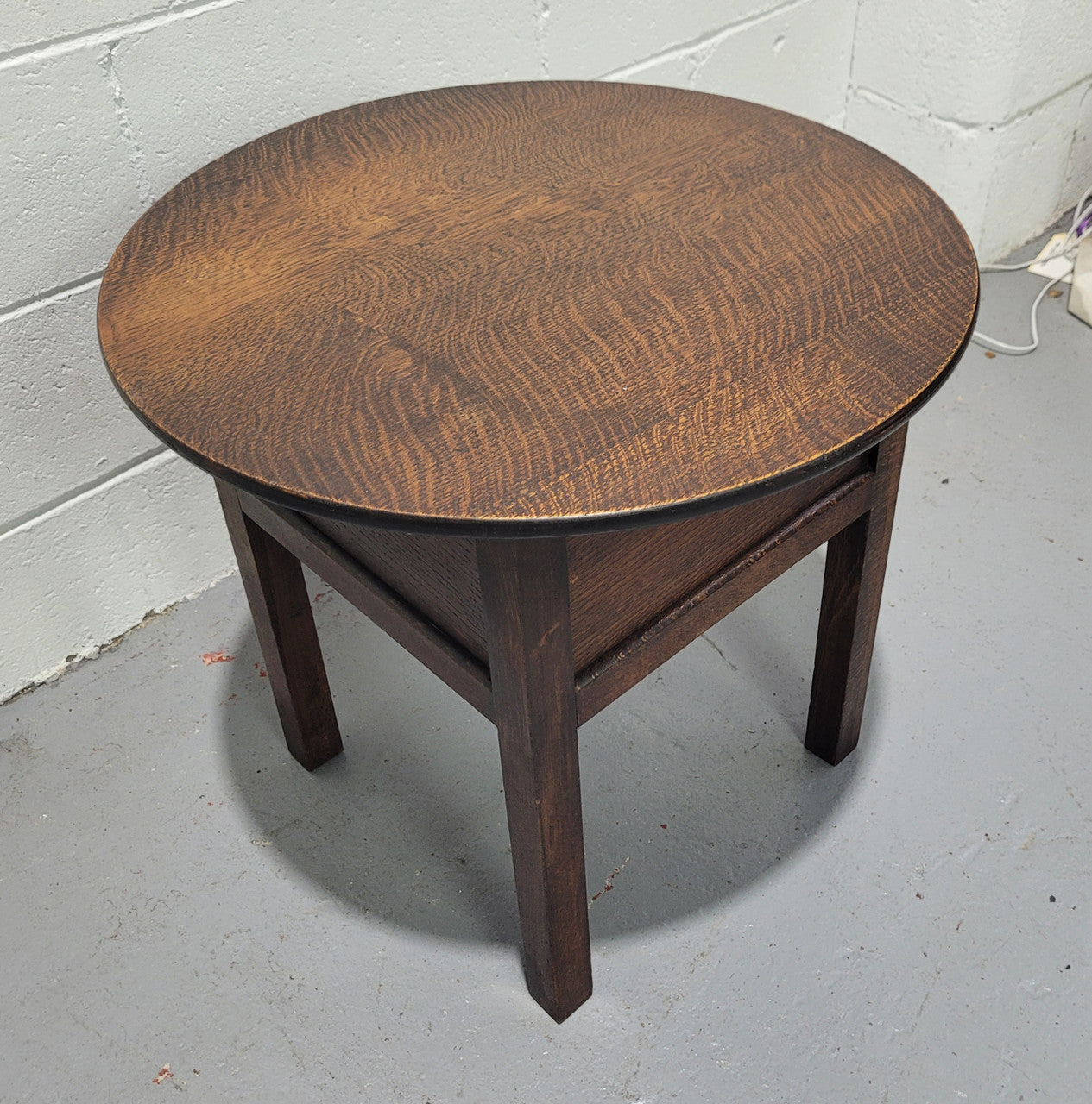 Fabulous round oak side table which also has a hidden sewing box underneath with lovely original blue satin lining and Includes pictured sewing items. It is in good original condition.