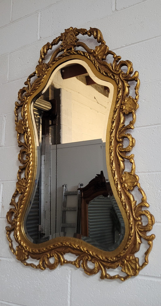 Large Vintage Italian carved wood gilt mirror. It has a beautiful bevelled mirror and has been sourced from France. It is in good original condition.