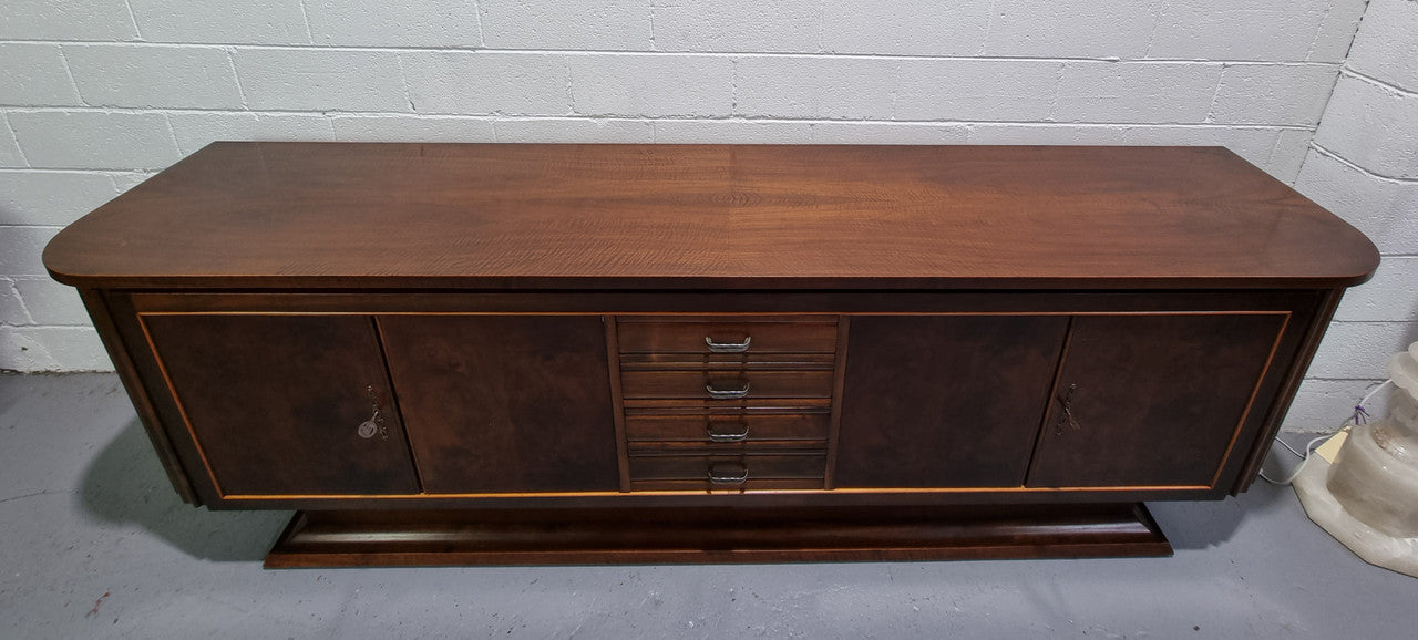 Amazing French Walnut Art deco four door buffet. The doors either side open to a fixed shelf and plenty of added storage with four drawers. In good original detailed condition.
