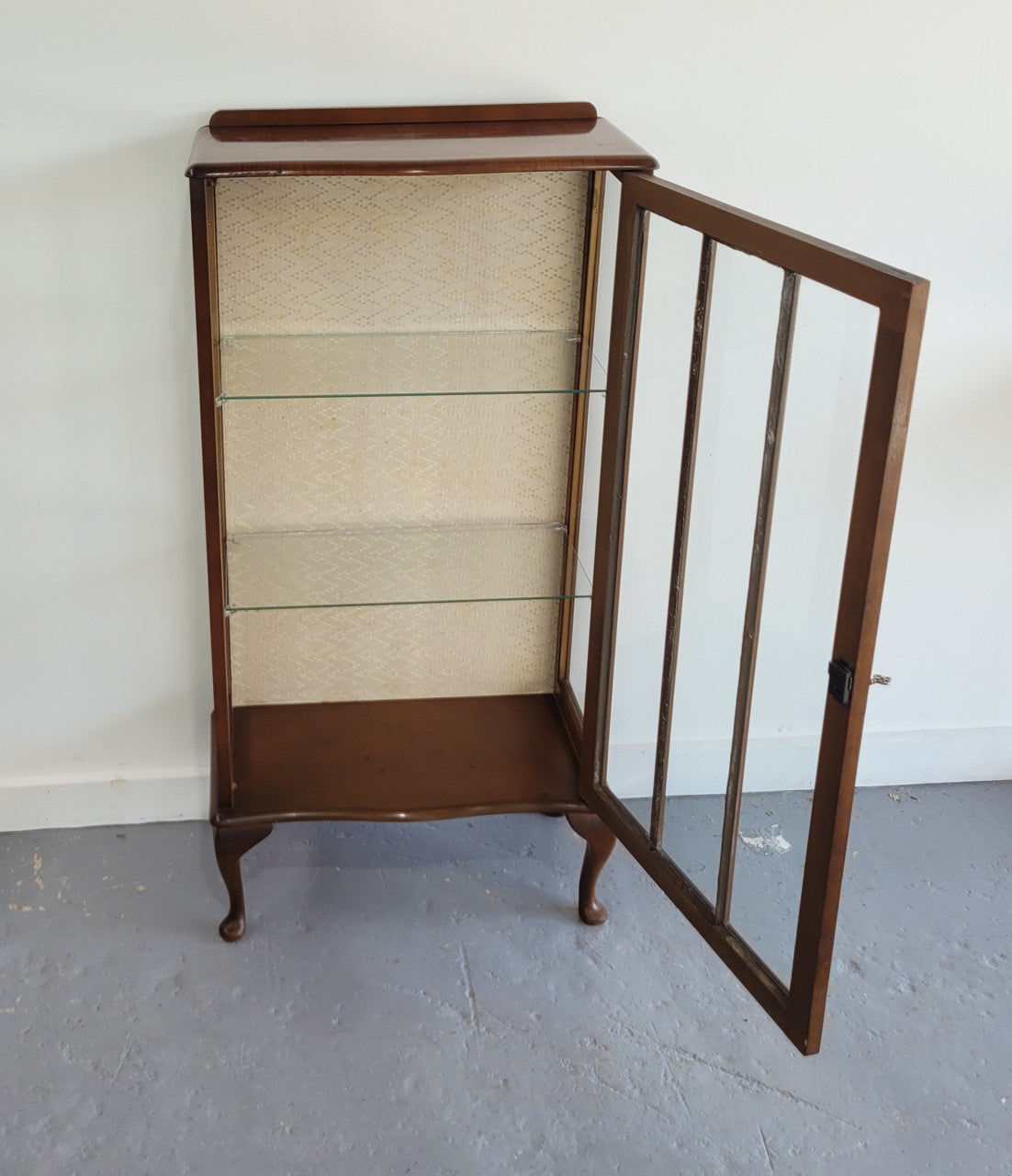 Petite single door Walnut display cabinet. Art Deco style with glass display door and two fixed shelves. In original condition.