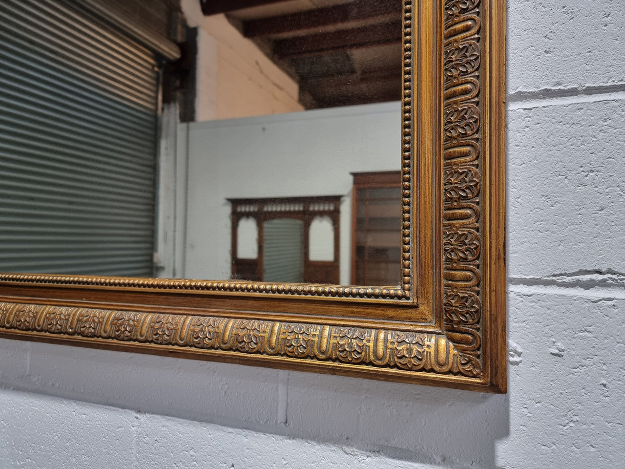 Late 19th century French gilt mirror with beautiful ribbon crest on top. In good original detailed condition.