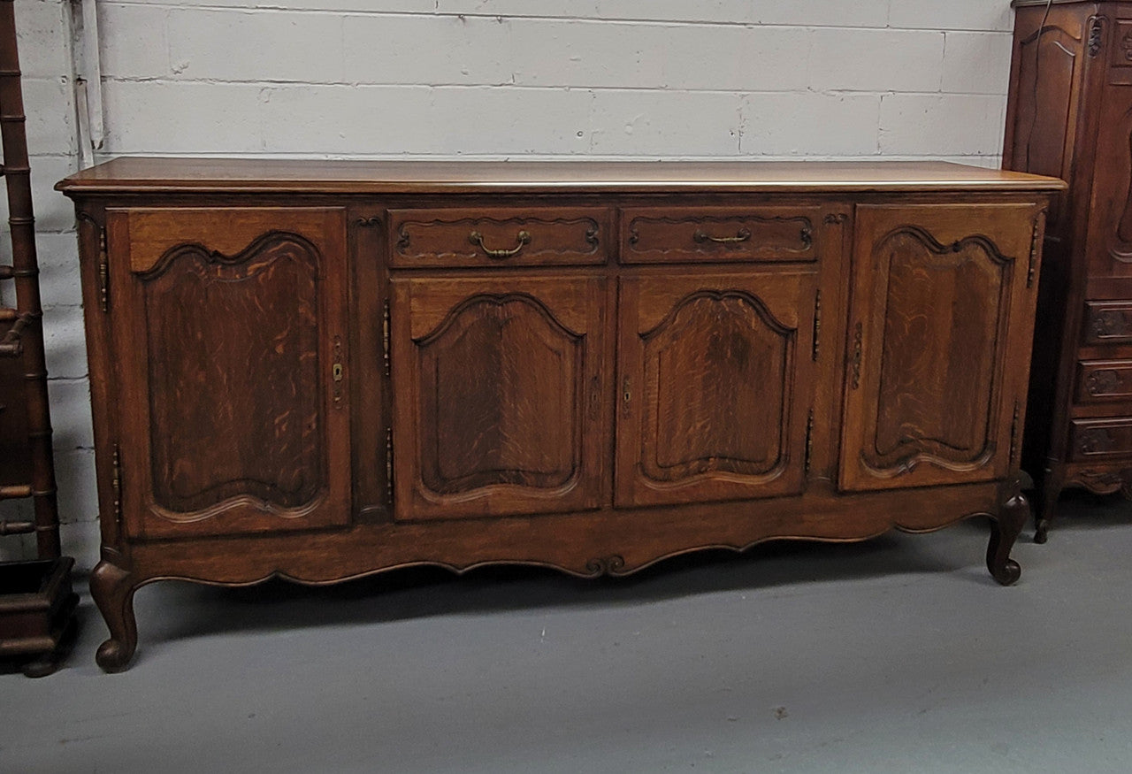 Louis XV style French Oak sideboard consisting of four doors and two drawers. It is in good restored condition.