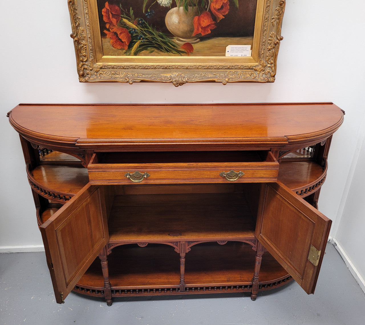 A high quality Antique Walnut sideboard featuring two mirrored doors, two drawers and five open shelf areas with mirror backing. It is in good original detailed condition.