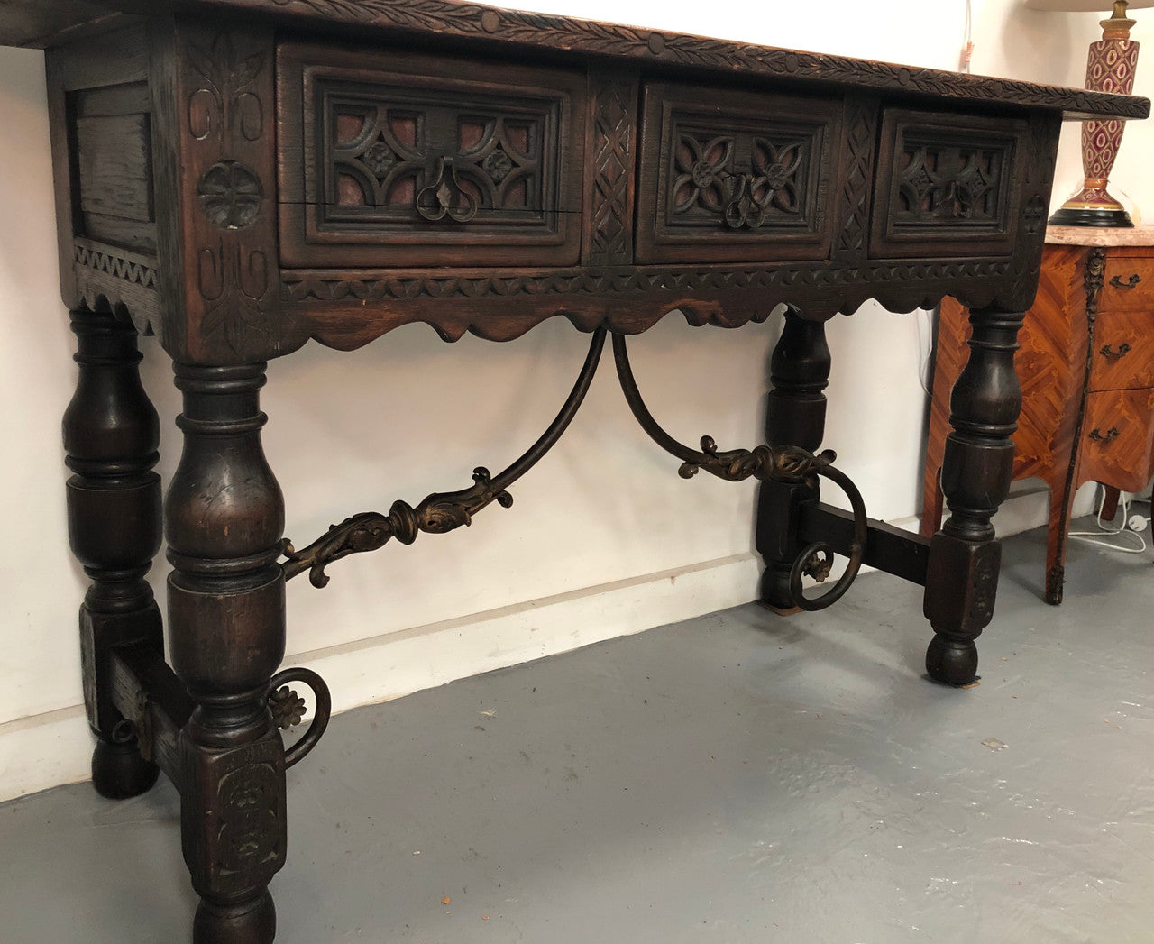 Spanish late 19th century carved oak three drawers console/side table. Superb wrought iron undercarriage. In good condition. Circa 1900's.