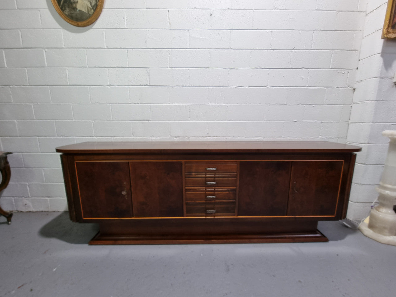 Amazing French Walnut Art deco four door buffet. The doors either side open to a fixed shelf and plenty of added storage with four drawers. In good original detailed condition.
