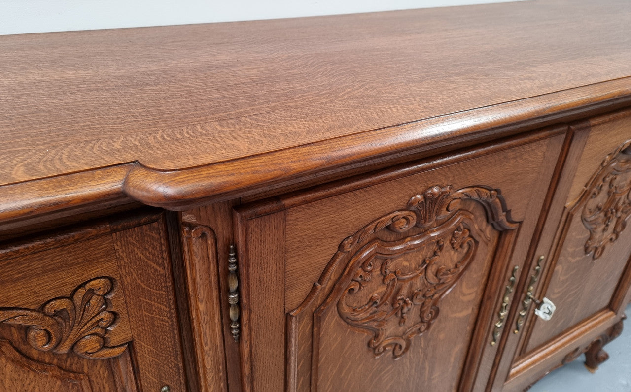 French oak large, beautifully carved four door sideboard with lockable doors and plenty of room for storage in good original condition.