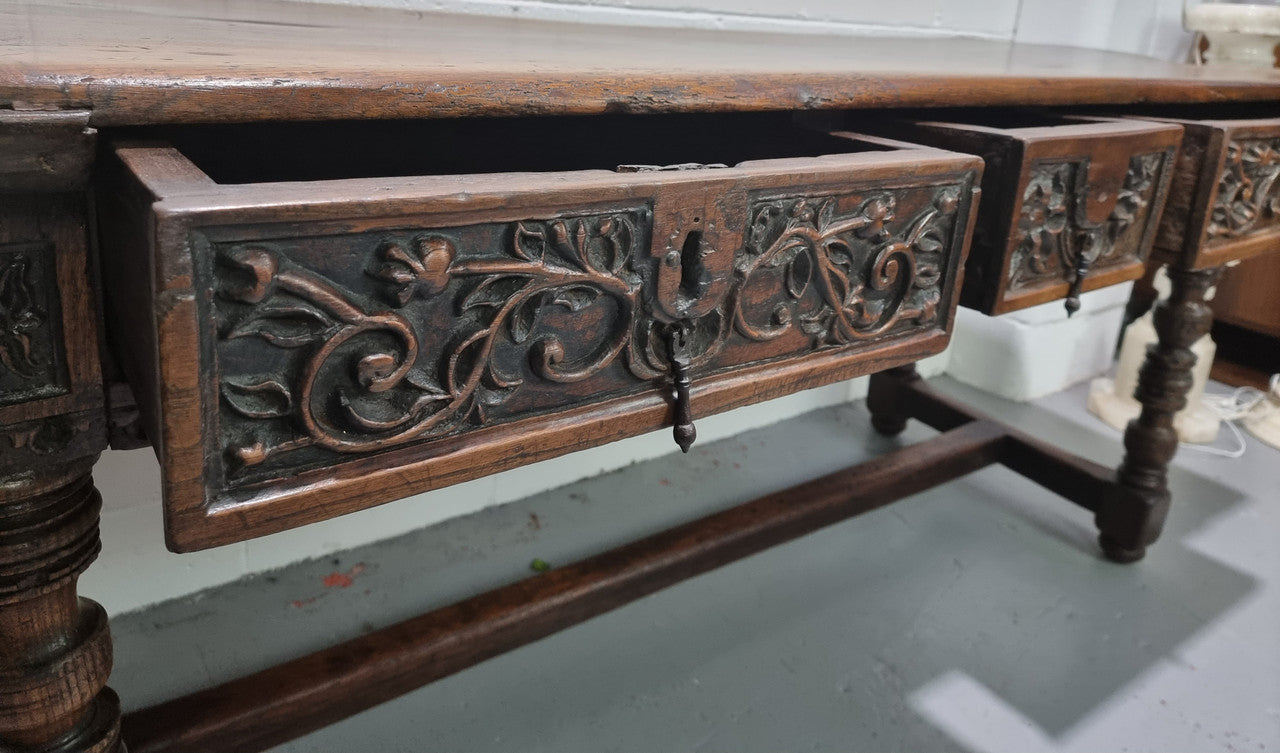 Rare and Charming 17th Century Spanish Walnut serving / side table. It has an incredible one piece walnut top with amazing character and colour. The base displays the original patina aswell as three drawers with carving and remnants of original locks. Superbly turned legs terminating on a stretcher base. Could be used as a large entrance console table, a side table or in a dining area as a serving table. In good original detailed condition especially considering its age.