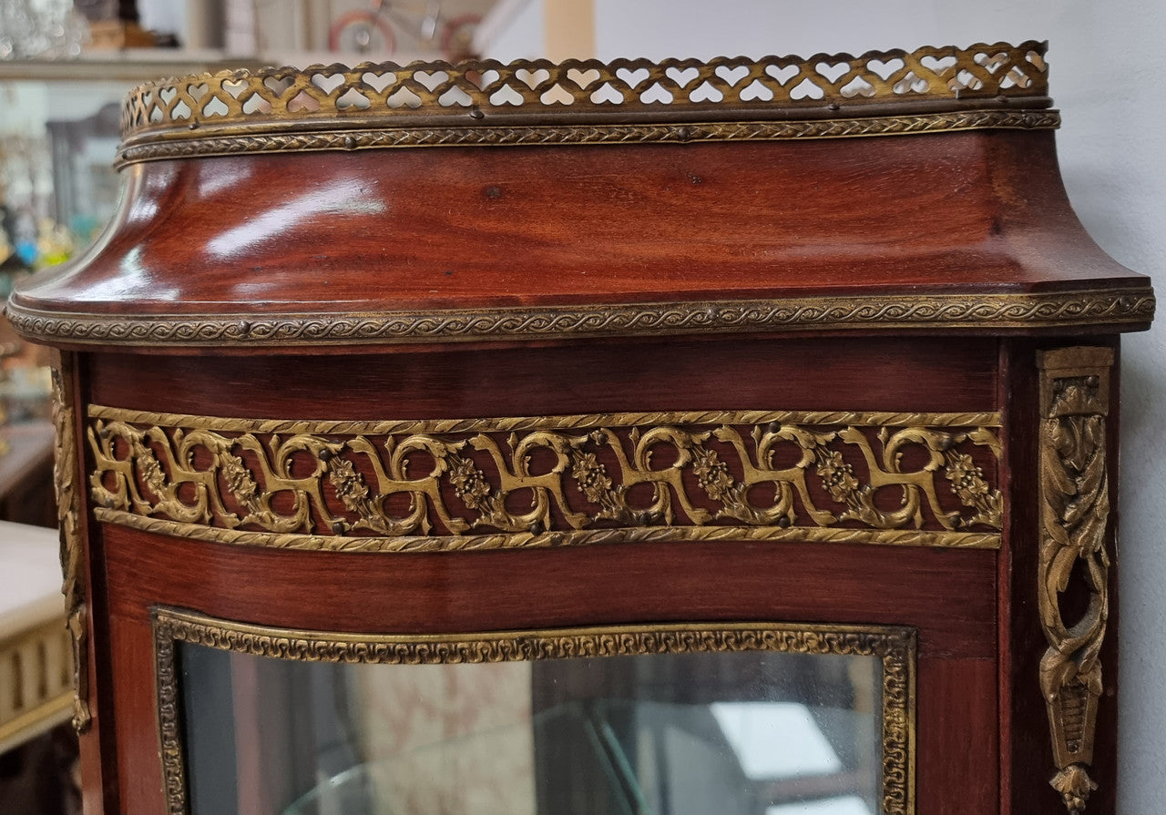 Beautiful French Louis XV style vitrine/ display cabinet with curved glass, gilt mounts, mirrored back and two glass shelves for your displays . It is in good original detailed condition.