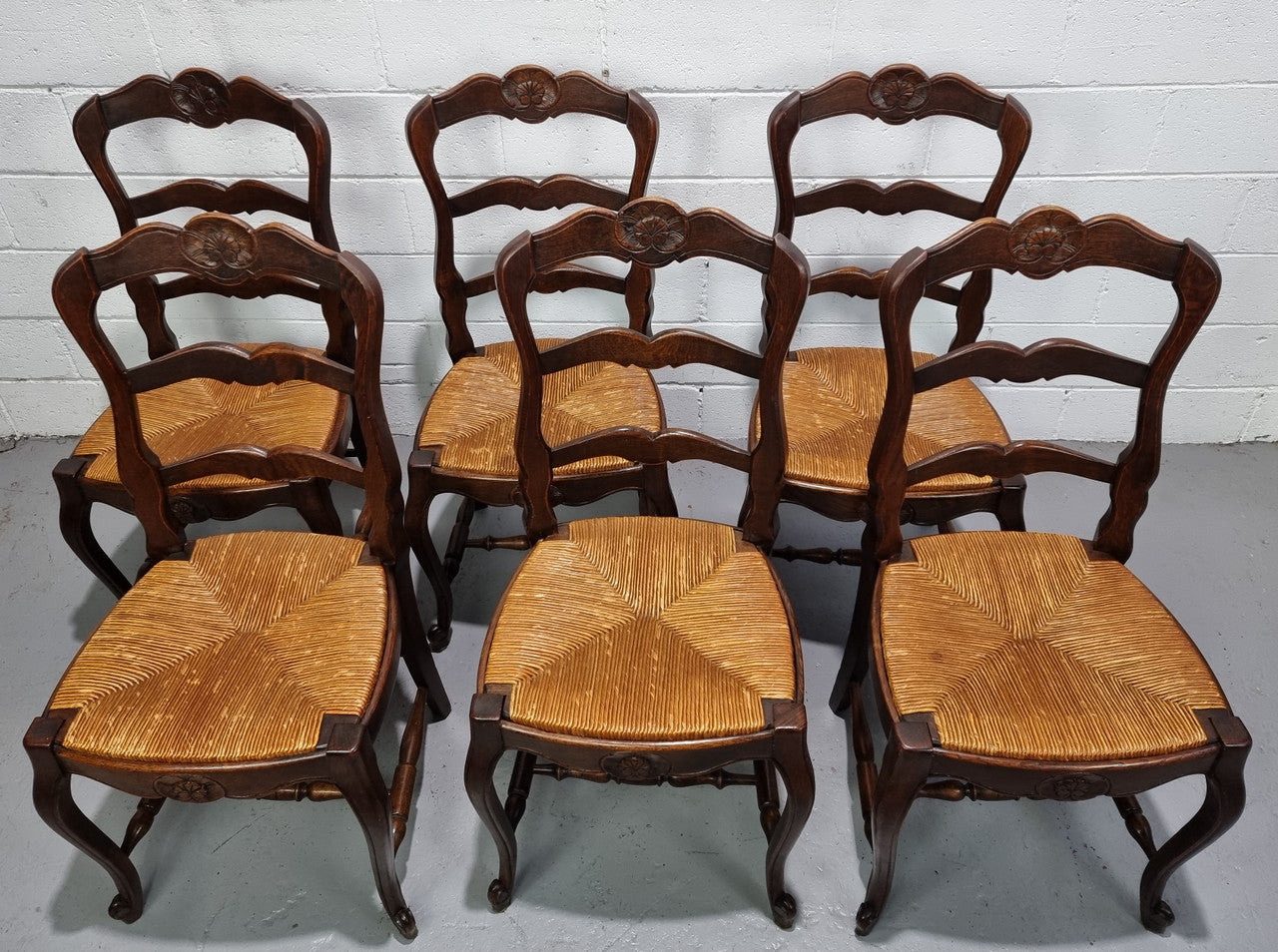 Set of six French dark Oak rush seat dining chairs with ladder back. They are in good detailed original condition and very comfortable to sit in.