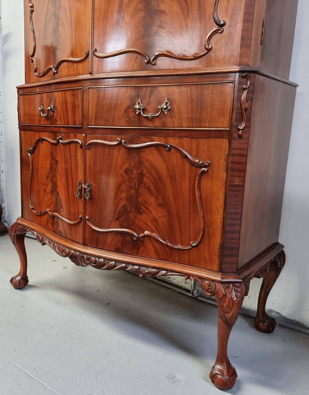 1950’s Chippendale Style Flame Mahogany Four door Bar. The top section has glass shelves and a mirrored pull out tray for storing glasses, decanters & serving etc. It also has a silver presentation plaque to the Mayor of Hawthorn 1958. The bottom section is for storage bottles etc. A stunning and practical piece.