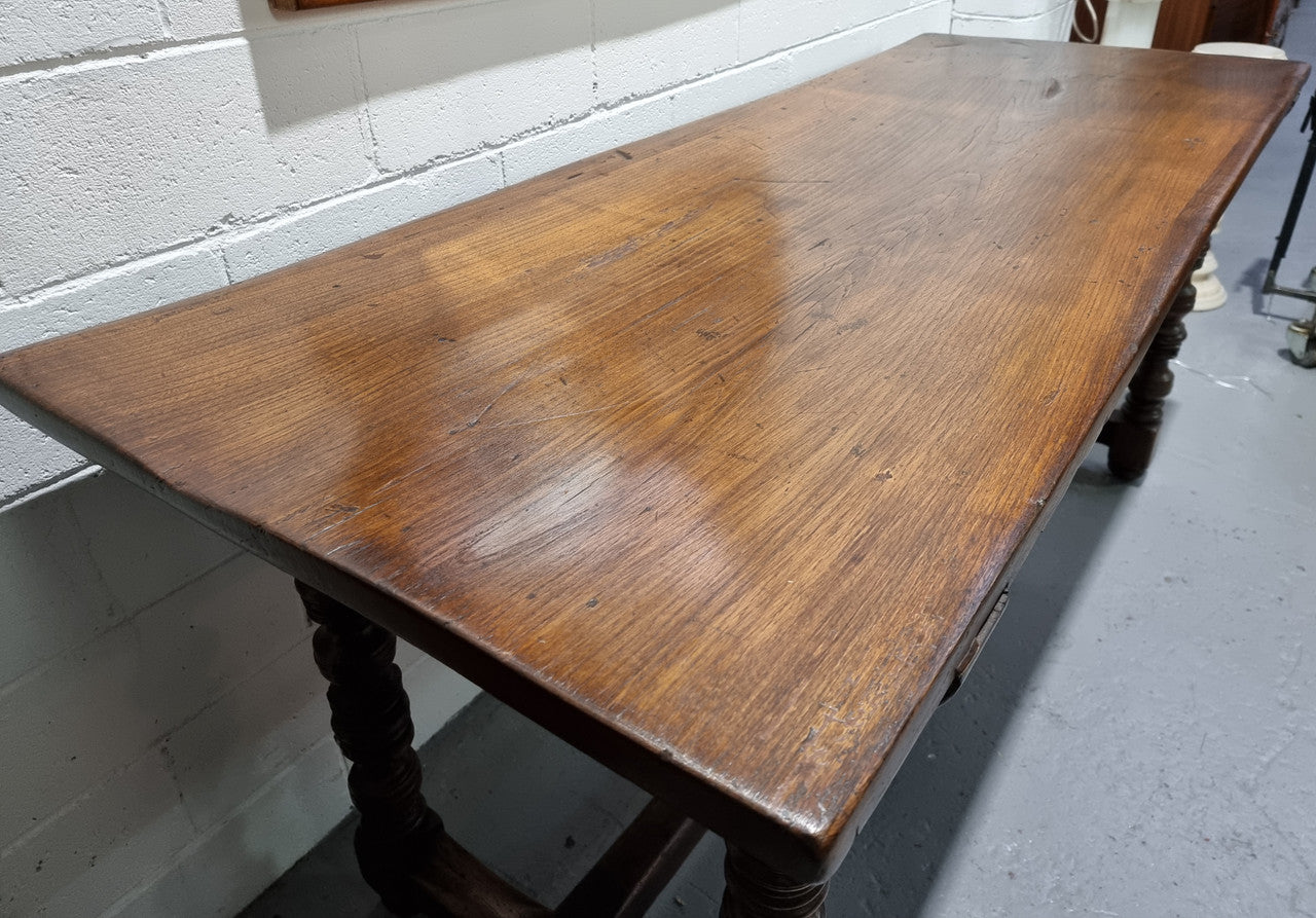 Rare and Charming 17th Century Spanish Walnut serving / side table. It has an incredible one piece walnut top with amazing character and colour. The base displays the original patina aswell as three drawers with carving and remnants of original locks. Superbly turned legs terminating on a stretcher base. Could be used as a large entrance console table, a side table or in a dining area as a serving table. In good original detailed condition especially considering its age.