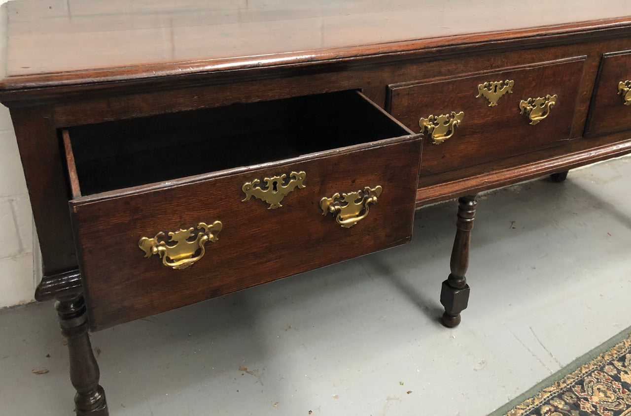 Early 19th Century English Oak dresser base with three large drawers. In very good original detailed condition.