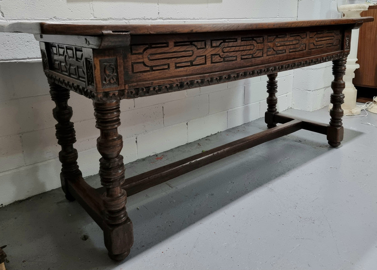 Rare and Charming 17th Century Spanish Walnut serving / side table. It has an incredible one piece walnut top with amazing character and colour. The base displays the original patina aswell as three drawers with carving and remnants of original locks. Superbly turned legs terminating on a stretcher base. Could be used as a large entrance console table, a side table or in a dining area as a serving table. In good original detailed condition especially considering its age.