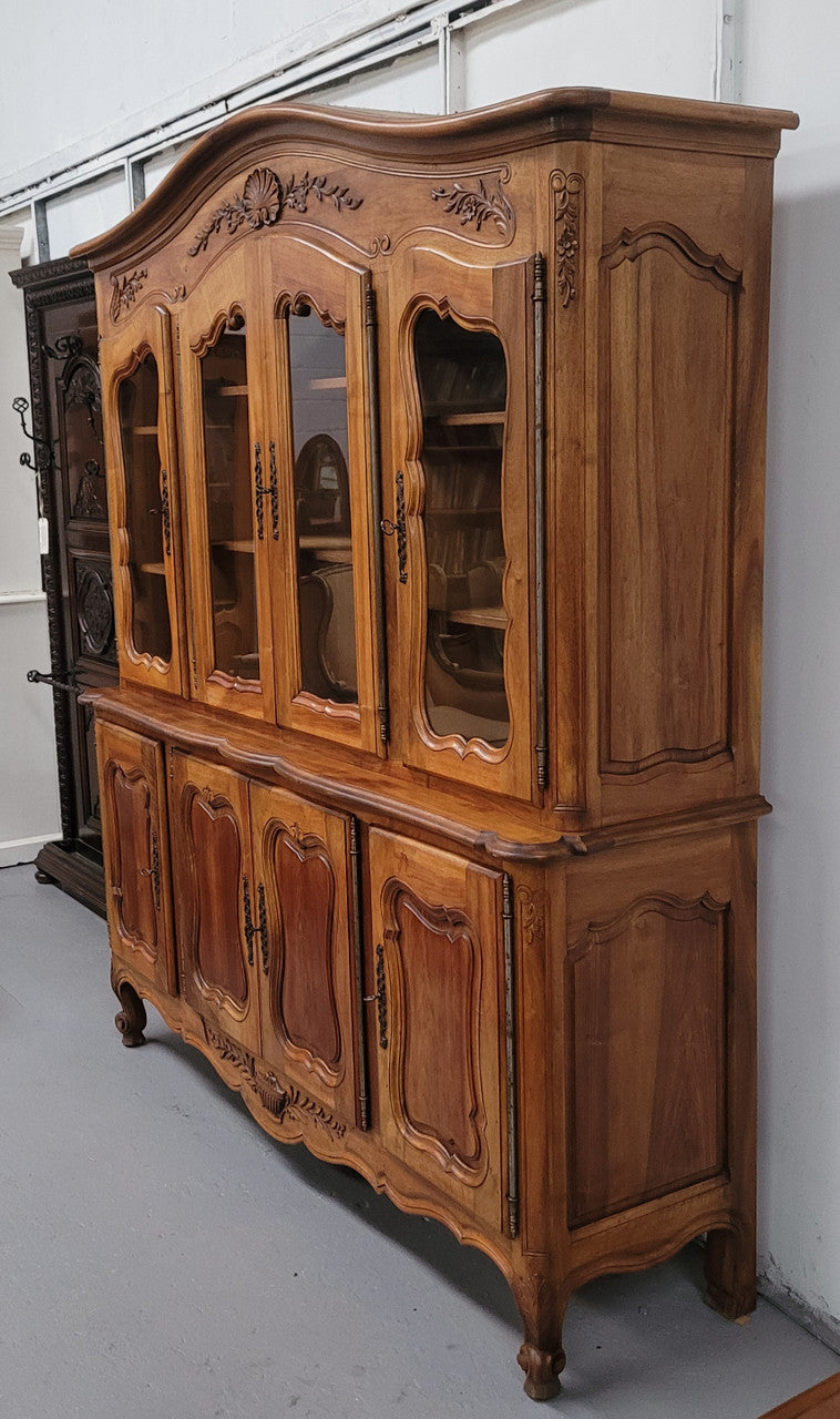 Magnificent French Walnut two-body four door display cabinet. Heaps of storage space with four glass doors at the top with shelves and four solid doors below also with shelving. It has been sourced from France and comes with a key for each door and all are lockable. In good original detailed condition.