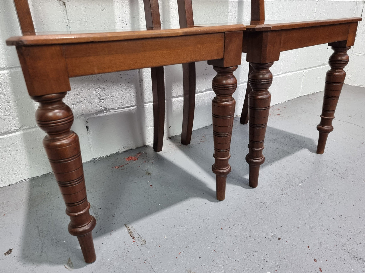Pair of Edwardian Mahogany hall chairs with original tile in back. They are in very good original detailed condition.