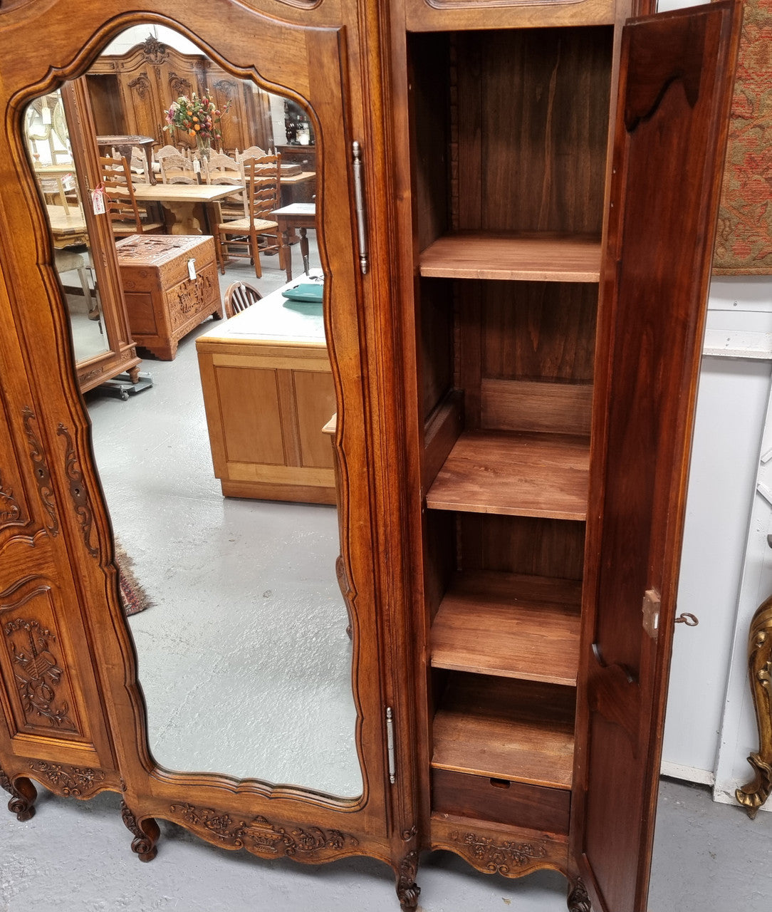 French Walnut Louis XV style three door armoire with 10 fully adjustable shelves in total spread over three sections, two drawers and a mirrored middle door. It has been sourced from France and in good original detailed condition.