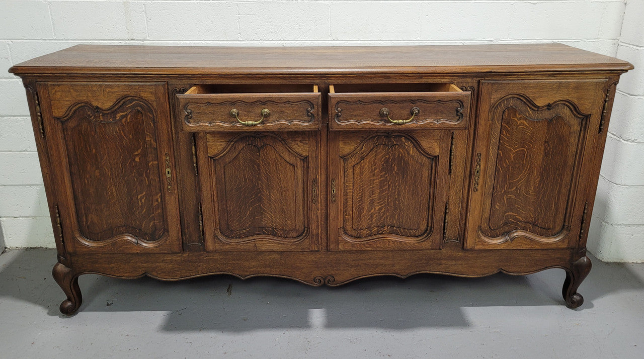 Late 19th Century French carved Oak Louis XV style four drawer sideboard. Plenty of storage space with four cupboards and two drawers. It is in good original detailed condition with all locks functioning with keys.