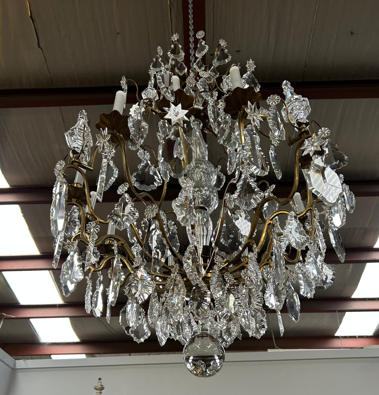 Louis XV 18th Century important cage shaped Castle Chandelier with 12 bronze scones and adorned with 8 daggers and large cut crystal prisms and the barrel threaded with cut glass pieces and finished with a large glass ball. The chandelier has beautiful proportions and is very well balanced in its arrangement of the crystals etc. The chandelier was sourced from Paris and comes with the majority of its original crystals intact. There are 6 internal lights and combined with the 12 sconces offers a dazzling arr