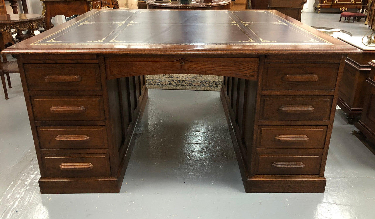 Lovely large English oak partners desk, with a beautiful burgundy tooled leather top. Plenty of storage space, both sides have 9 functioning drawers. It is in very good condition.