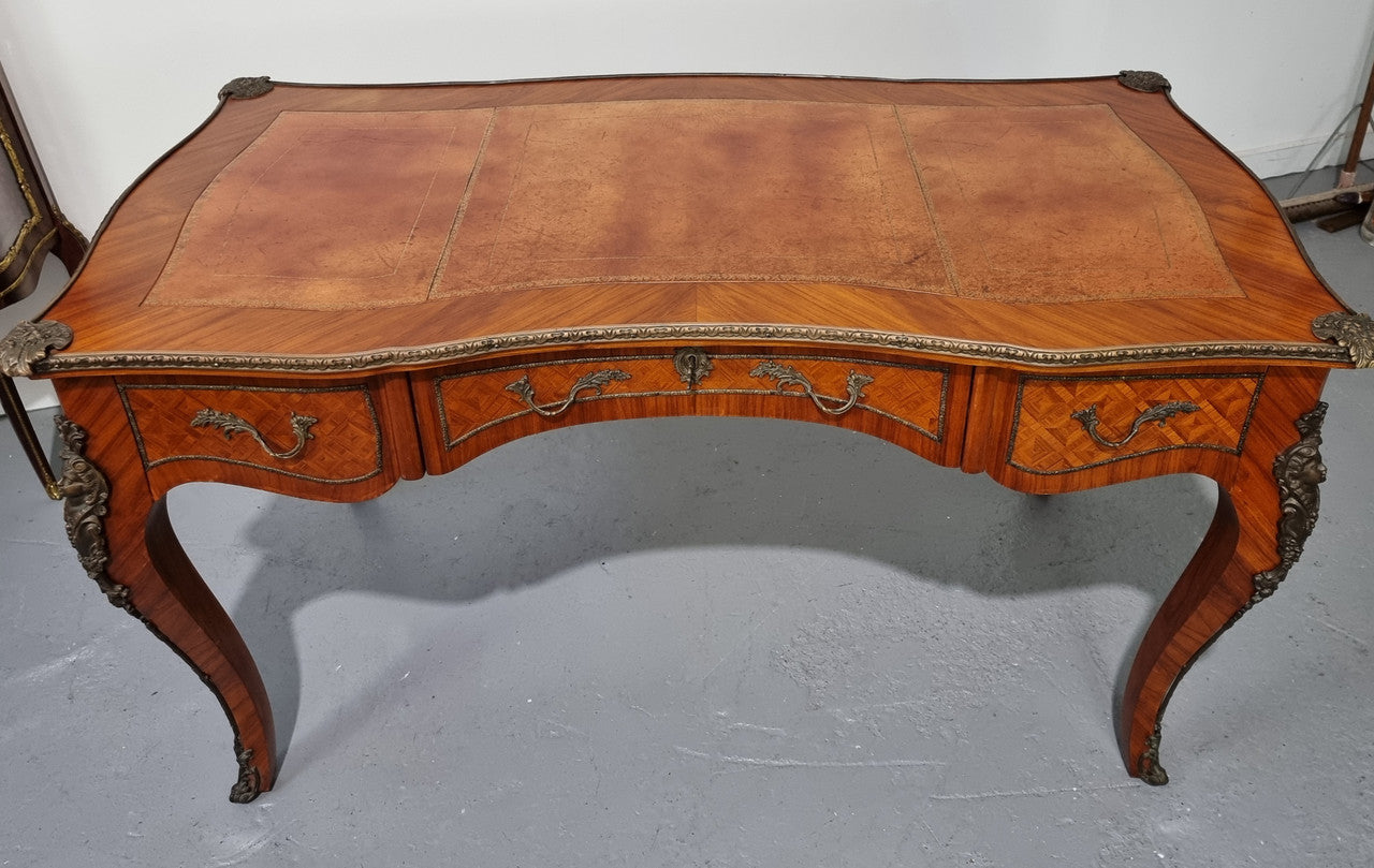 An impressive French kingwood and ormolu mounted bureau plat. It has a brown tooled leather writing surface, three decorated frieze drawers to the shaped apron with foliate swing handles and well cast figural mounts. Beautiful cabriole legs with decorative ormolu mounts and trims throughout. In good original detailed condition.