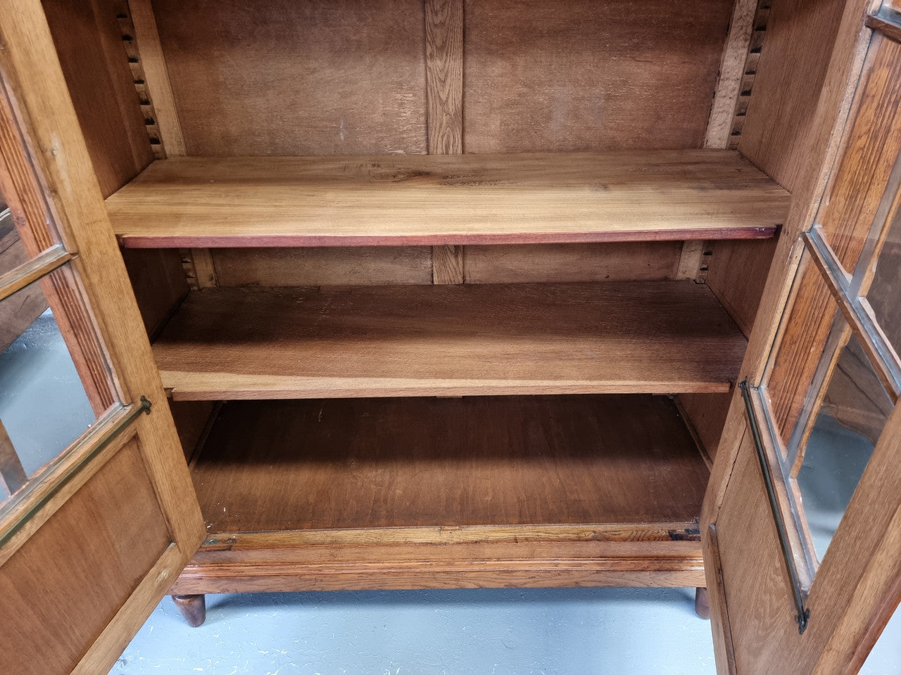 French light Oak two door bookcase with four adjustable shelves. It has beautiful decorative carving and is in good original detailed condition.