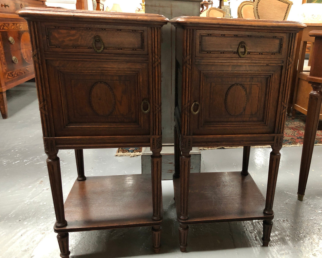 Lovely pair of French Oak Louis XVI style bedside cabinets with inset marble tops a drawer and a cupboard for storage. In good original detailed condition.