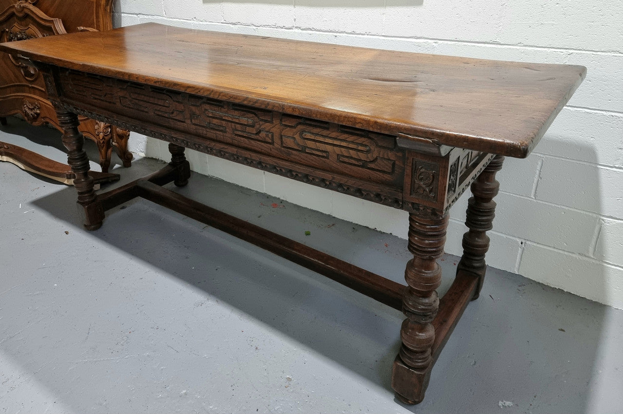 Rare and Charming 17th Century Spanish Walnut serving / side table. It has an incredible one piece walnut top with amazing character and colour. The base displays the original patina aswell as three drawers with carving and remnants of original locks. Superbly turned legs terminating on a stretcher base. Could be used as a large entrance console table, a side table or in a dining area as a serving table. In good original detailed condition especially considering its age.