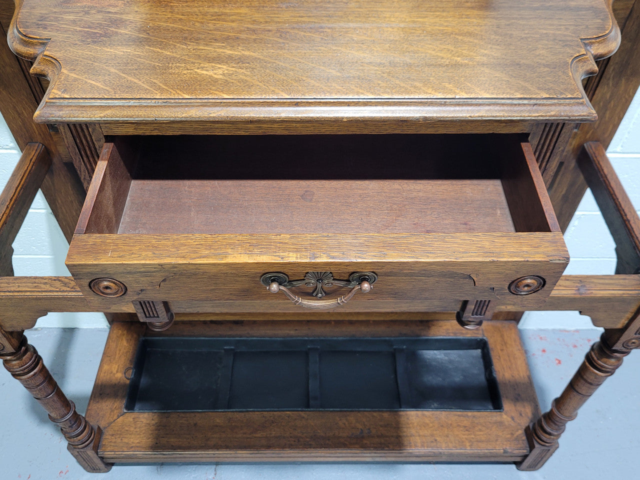 Impressive Oak hall stand of grand portions. Plenty of storage with a drawer, plenty of hooks and two sections for umbrealls/ walking sticks. It is in good original detailed condition.