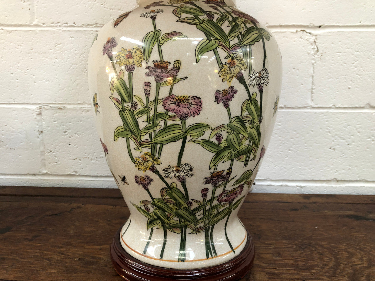 Contemporary ceramic lamp base decorated with daises & butterflies on a wooden base with shade.
