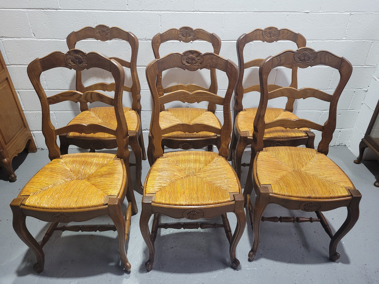 Set of six French Louis 15th style rush seated dining chairs. They are comfortable to sit in and are in original condition.