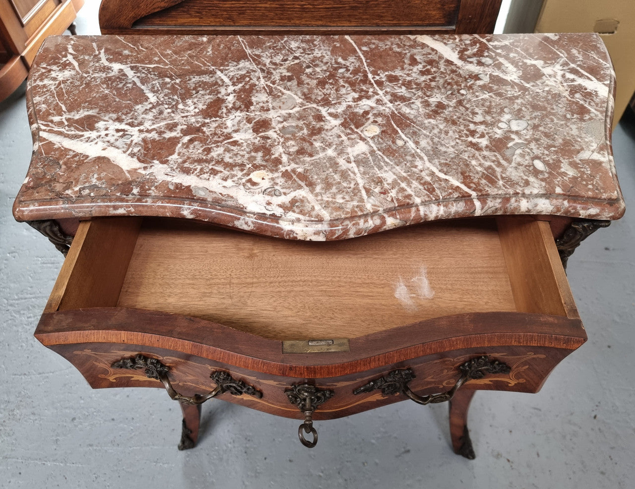 Antique French Louis XV style compact three drawer marble top commode with marquetry inlay and ormolu mounts. Sourced from France and in good original detailed condition.