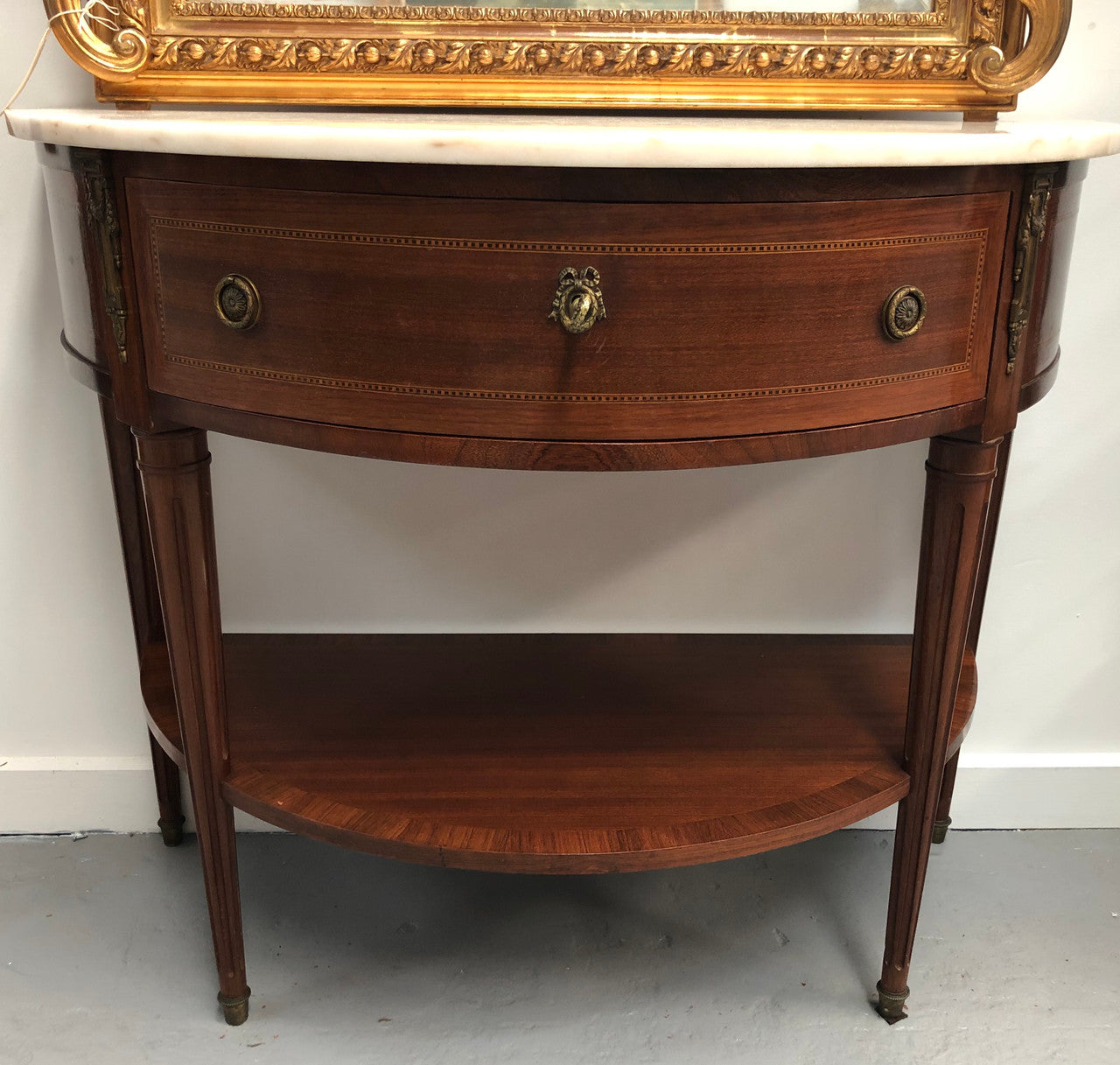 French marble top half round console table. It has beautiful marquetry inlay and ormolu mounts with a single drawer. In good original condition.