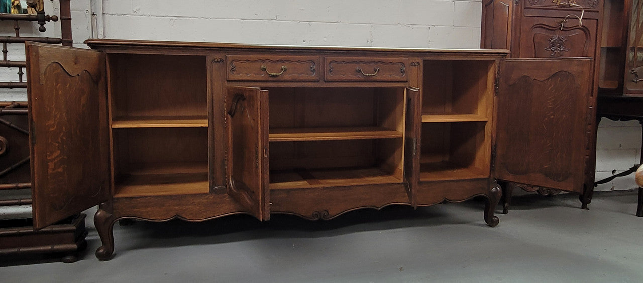 Louis XV style French Oak sideboard consisting of four doors and two drawers. It is in good restored condition.