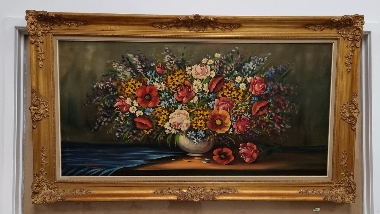 Sourced from France a stunning colorful floral oil painting on canvas. It is in a decorative gilt frame and is signed. It is in good original detailed condition.