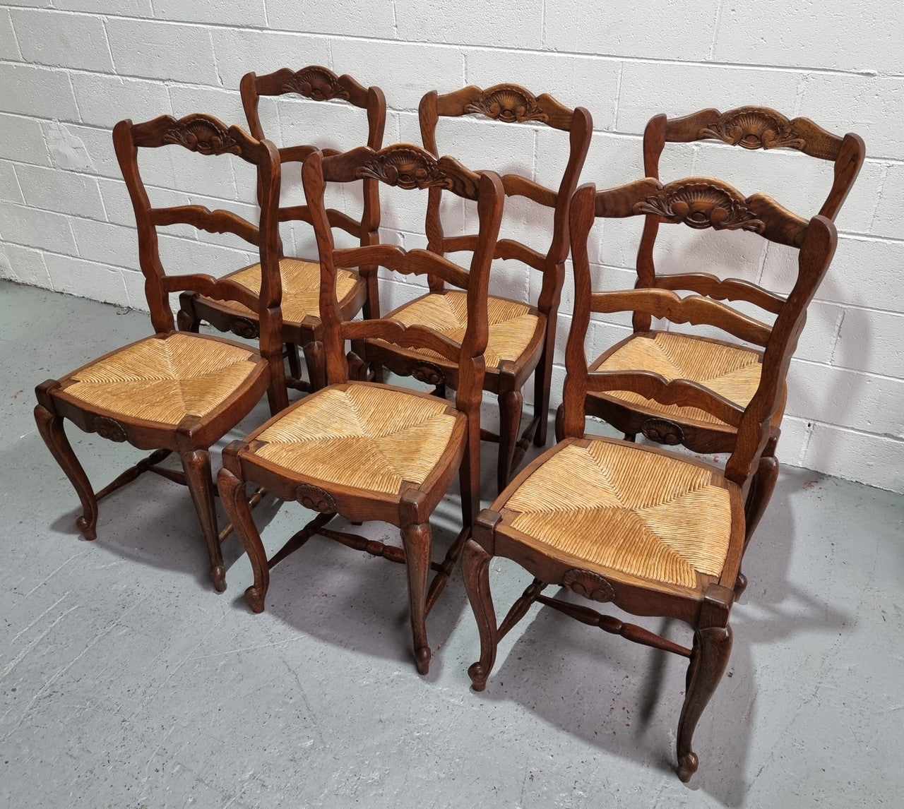 Lovely set of six French oak rush seated provincial dining chairs. They have been sourced from France and are in good detailed condition.
