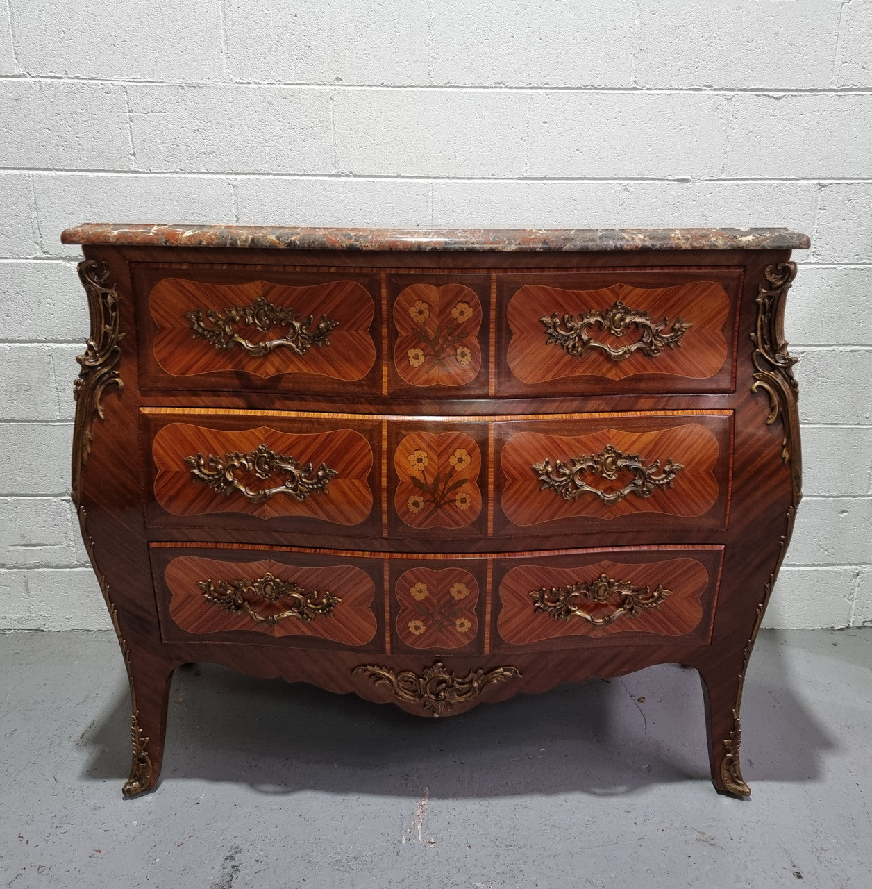French Walnut and Kingwood Louis XV style marquetry inlaid commode with three drawers and a beautiful marble top. It is in good original detailed condition.