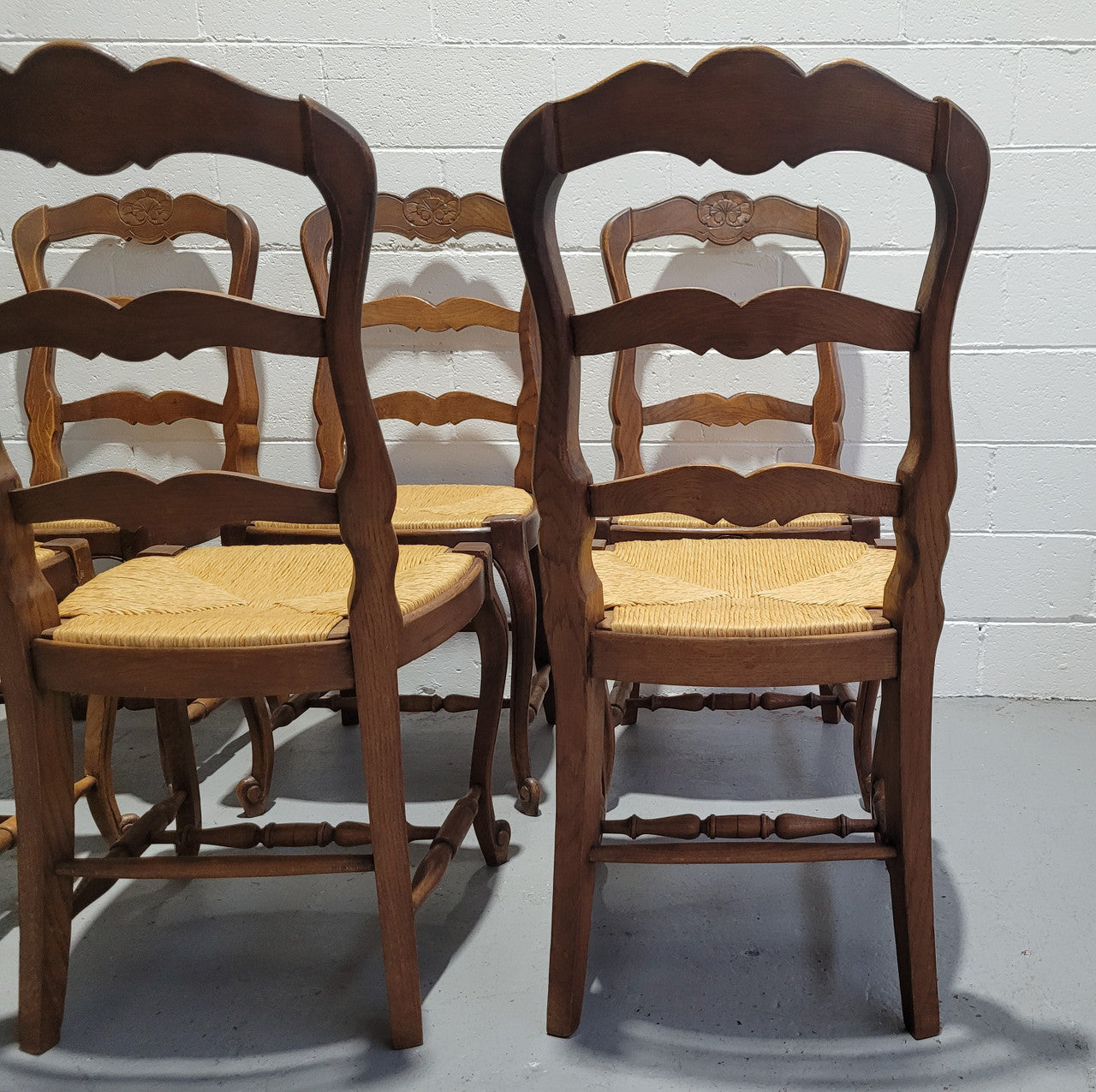 A stunning set of six French Louis XV Style oak dining chairs with rush seats in good original condition. All chairs have been detailed and re-glued where needed.