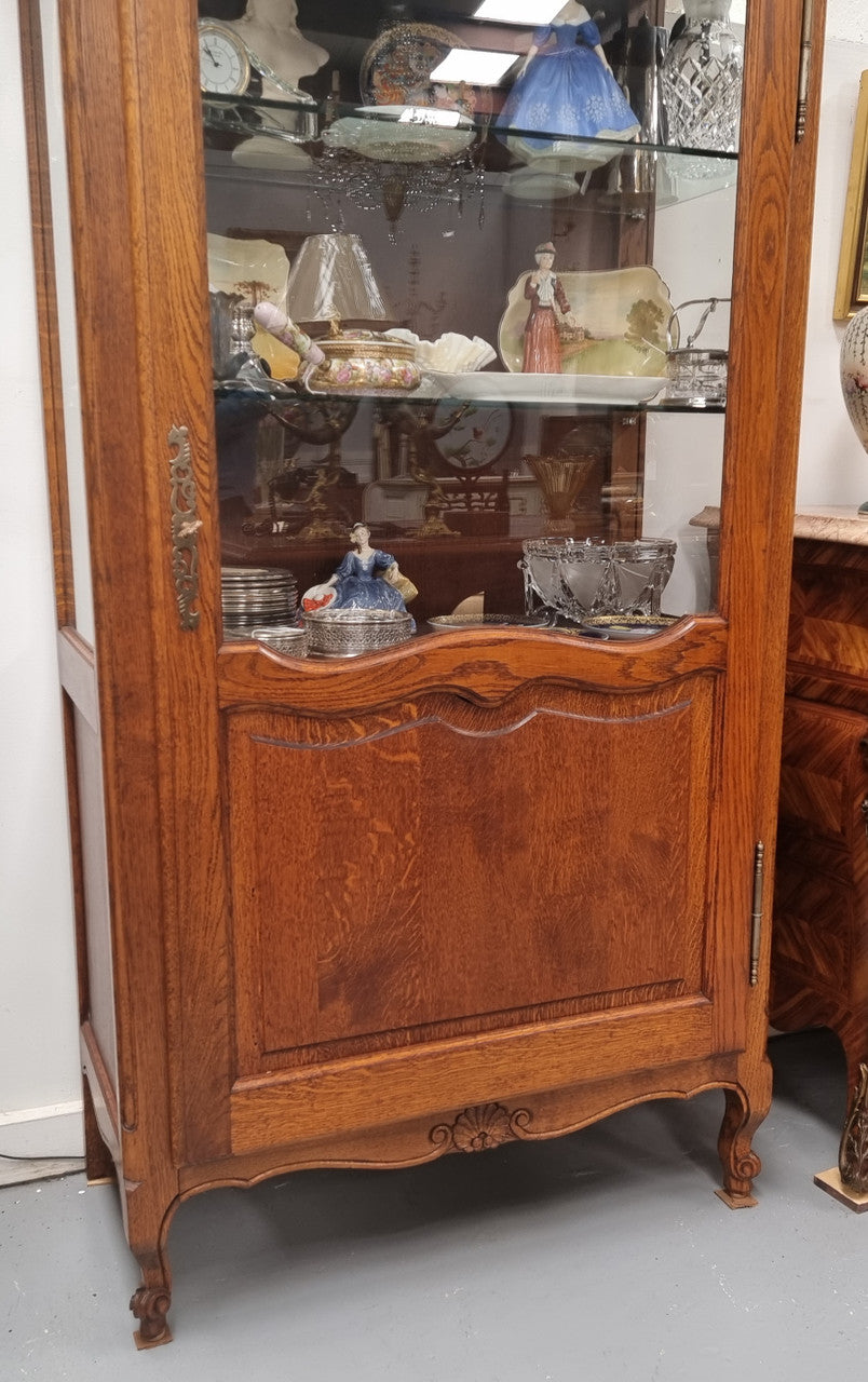 French Oak Louis XV Style Vitrine with two fixed glass shelves at the top and two fixed wooden shelves at the base for added storage. It has been sourced from France and in good original detailed condition.