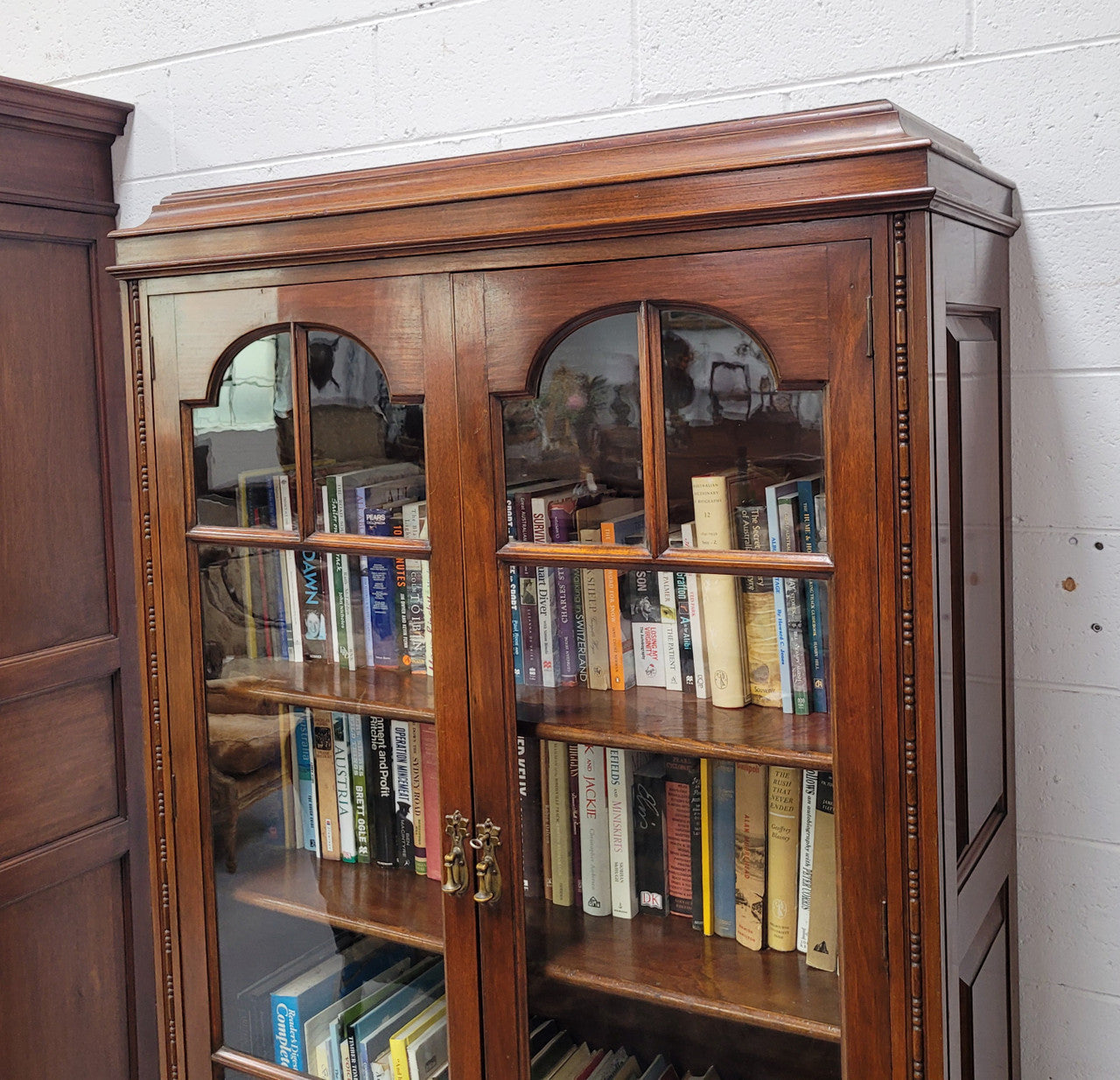 Beautiful four door Walnut bookcase with glass doors. The top section has two fully adjustable shelves and it is of pleasing narrow proportions. It is in good original detailed condition.