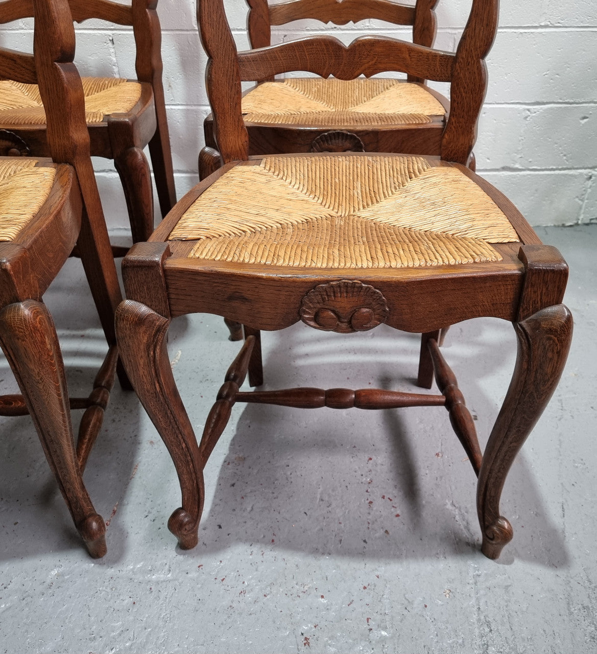 Lovely set of six French oak rush seated provincial dining chairs. They have been sourced from France and are in good detailed condition.
