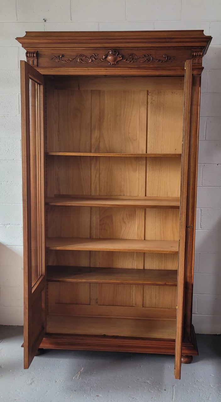 Stunning French Walnut Henry II style two door bookcase with four fully adjustable shelves. The lock on the door is functional and has a key. It is in good original detailed condition.