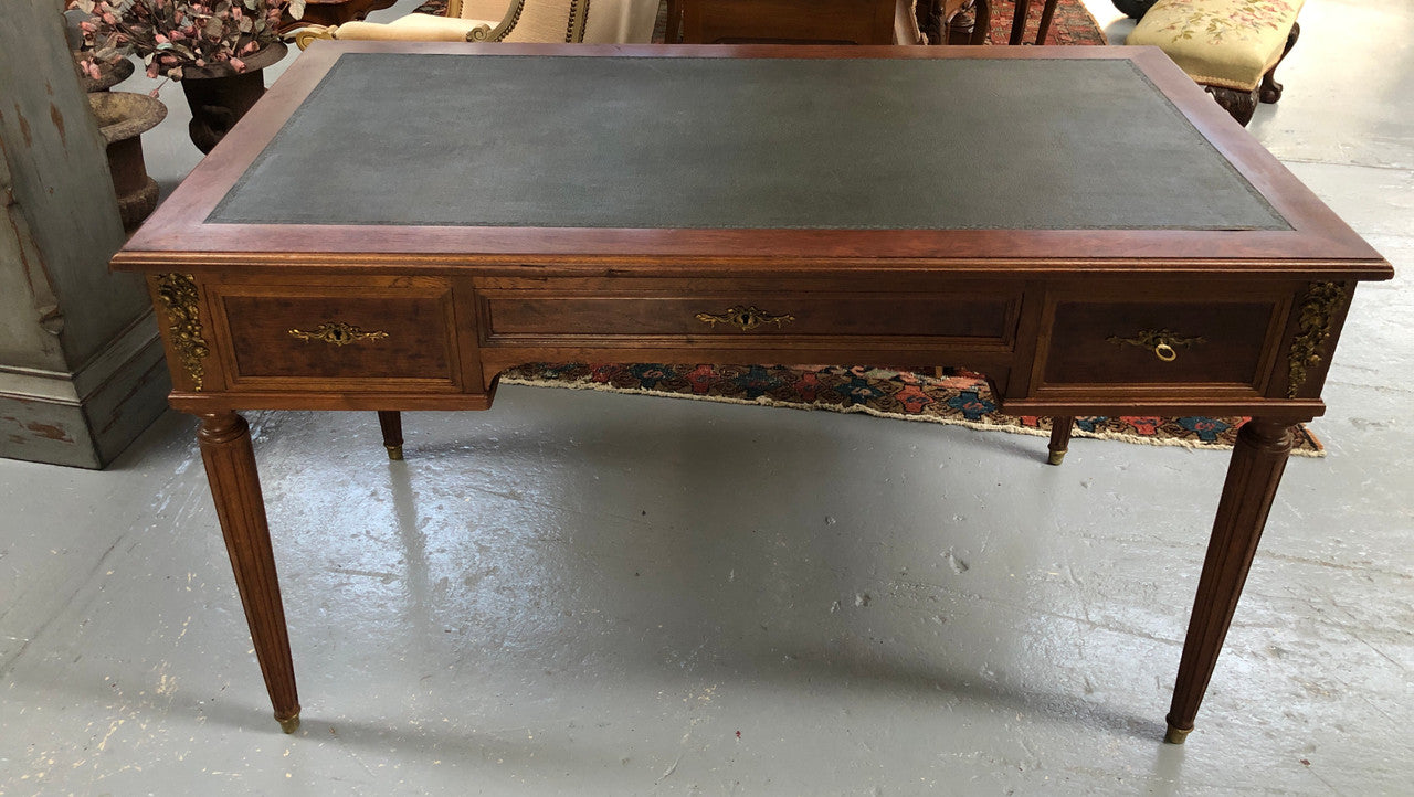 Lovely French Mahogany Louis XVI style leather top desk. With beautiful ormolu details and three drawers. There are also two slides on either side with tooled leather tops and in good original detailed condition.