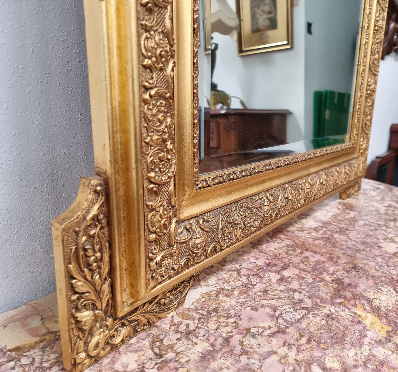 French ornate gilt decorated and floral bevelled mirror. It has been sourced from France and it is in good original condition.