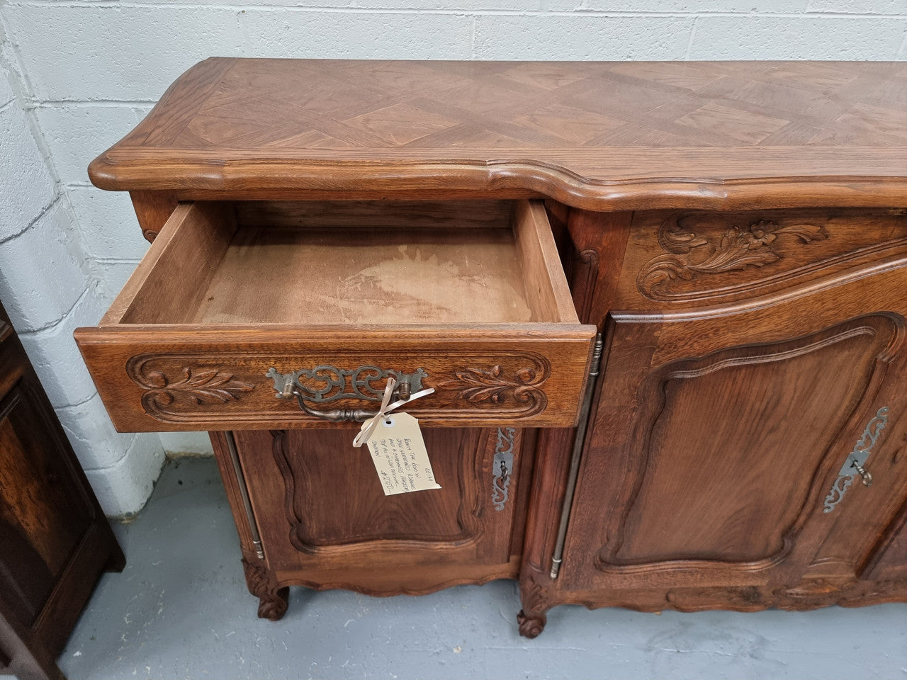 Parquetry top French oak Louis XV style sideboard with two draws and four cupboards. In good original detailed condition.