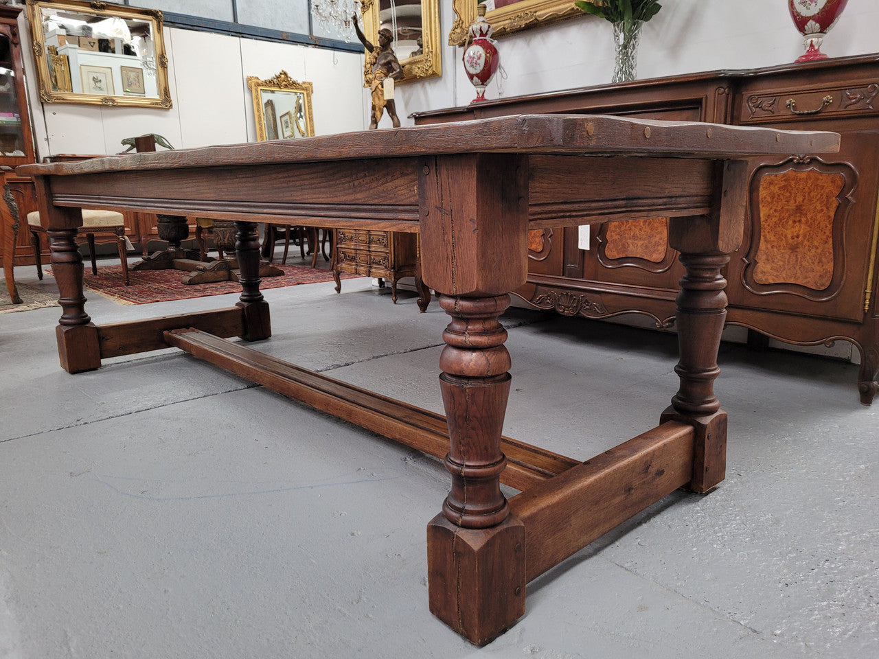 Charming solid rustic Oak stretcher base Farmhouse table. The table is circa 1950's and was custom made using reclaimed oak. It comfortable sits eight and could seat 10. It is in good original detailed condition.