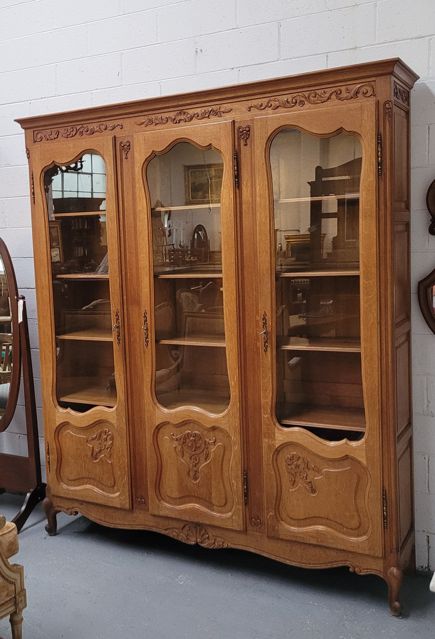 French Louis XV style light Oak three door bookcase with five fixed shelves. It has lovley glass doors and has been sourced from France. Is in good original detailed condition
