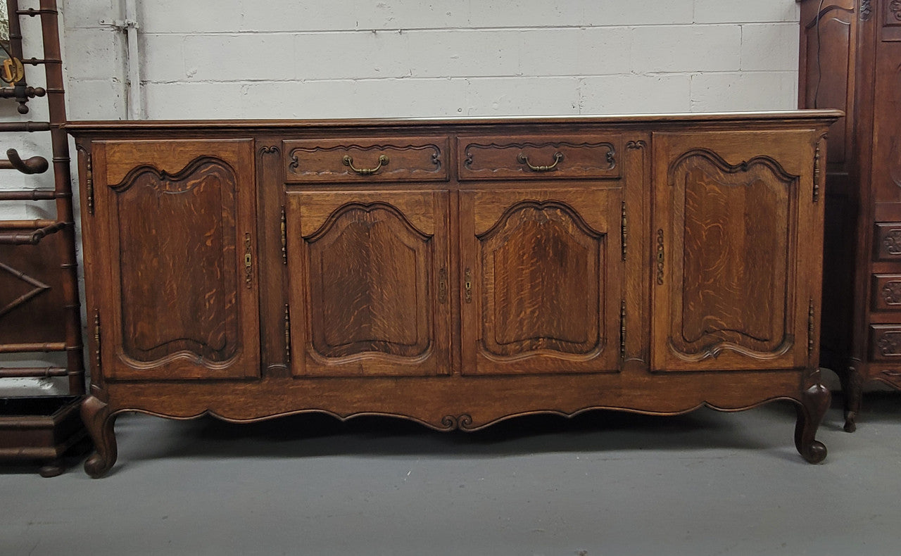 Louis XV style French Oak sideboard consisting of four doors and two drawers. It is in good restored condition.