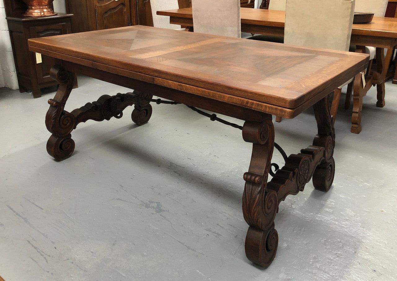 French Oak Renaissance style extension table with a lovely parquetry top and decorative carved and iron base in good original detailed condition.