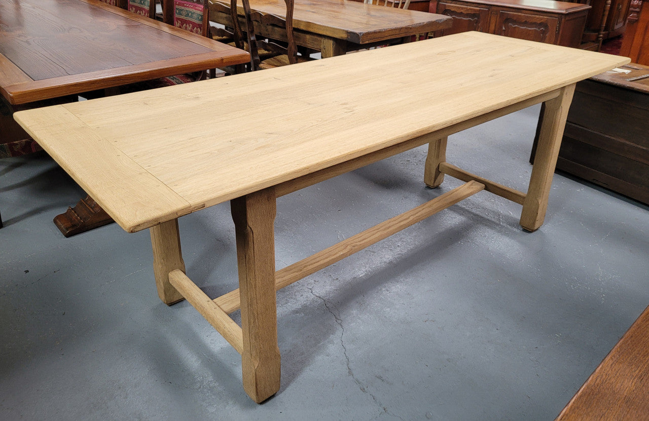 French raw Oak stretcher based refectory table. Features raw wood that could be used as is for a distressed look, or finished and waxed for a more refined look. Sourced from France and in good original condition.