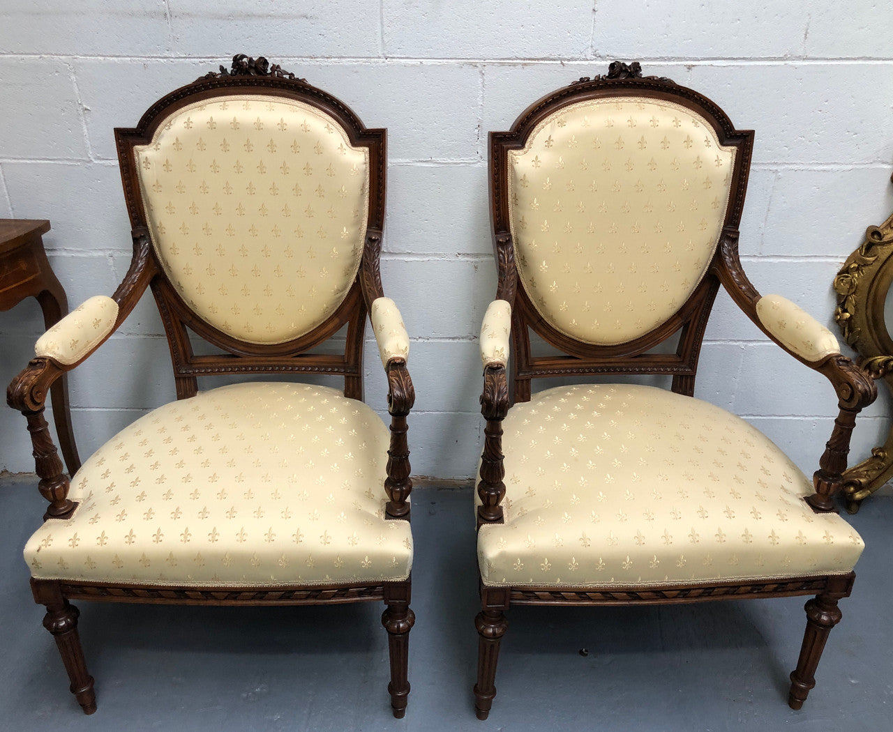 Beautiful pair of Vintage French Walnut Louis XVI style carved Fauteuils with lovely upholstery and wide seats . In good original detailed condition.